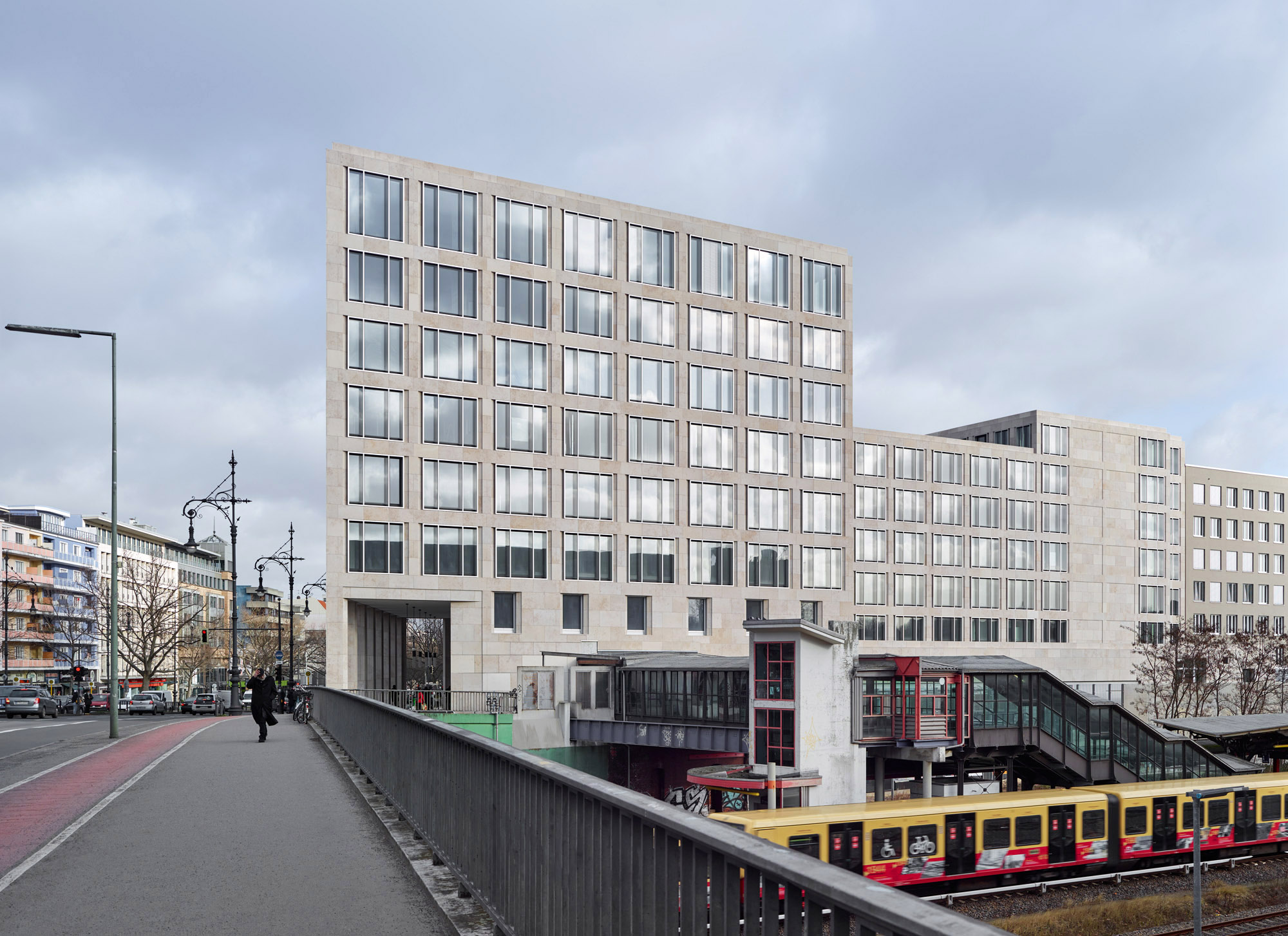 Büro- und Geschäftshaus am Kurfürstendamm Berlin - Eine zweigeschossige Arkade verbindet den bestehenden S-Bahnhof mit dem Henriettenplatz und verstärkt den öffentlichen Charakter des Hauses.